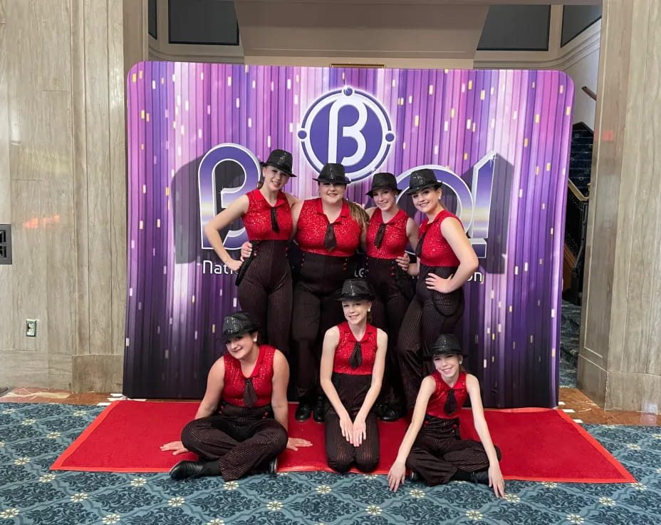 a group of women in red dresses