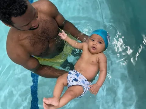 a man and a baby in a pool