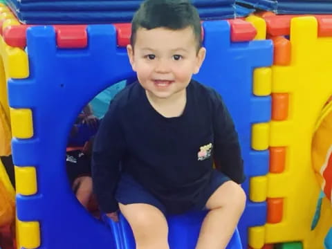 a boy sitting in a toy car