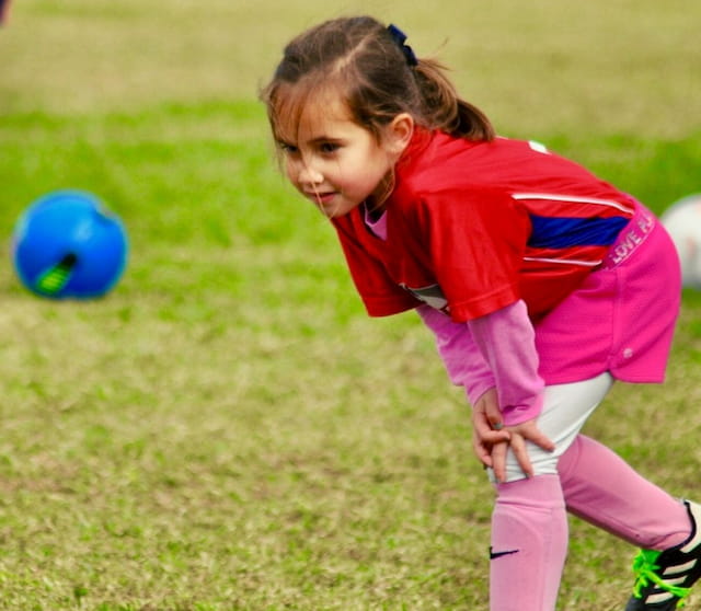 a girl kicking a ball