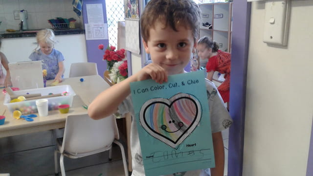 a boy holding a drawing