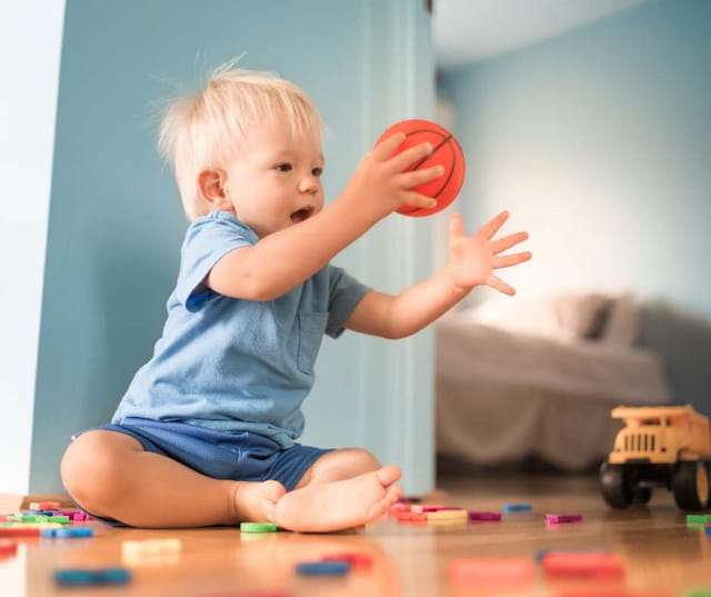 a baby playing with a ball