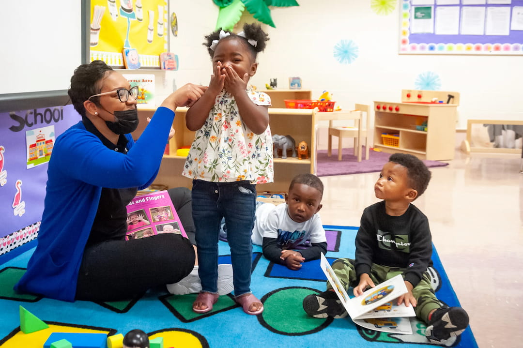 a group of people sitting on the floor with laptops