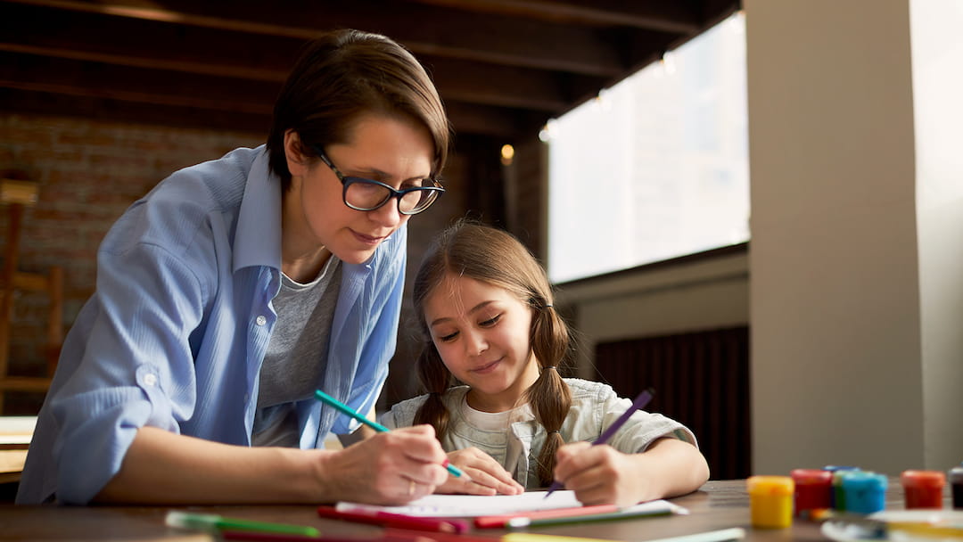 a woman and a girl looking at a paper
