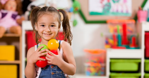 a little girl holding toys