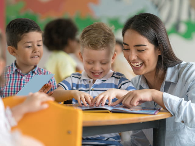 a person and several children looking at a computer