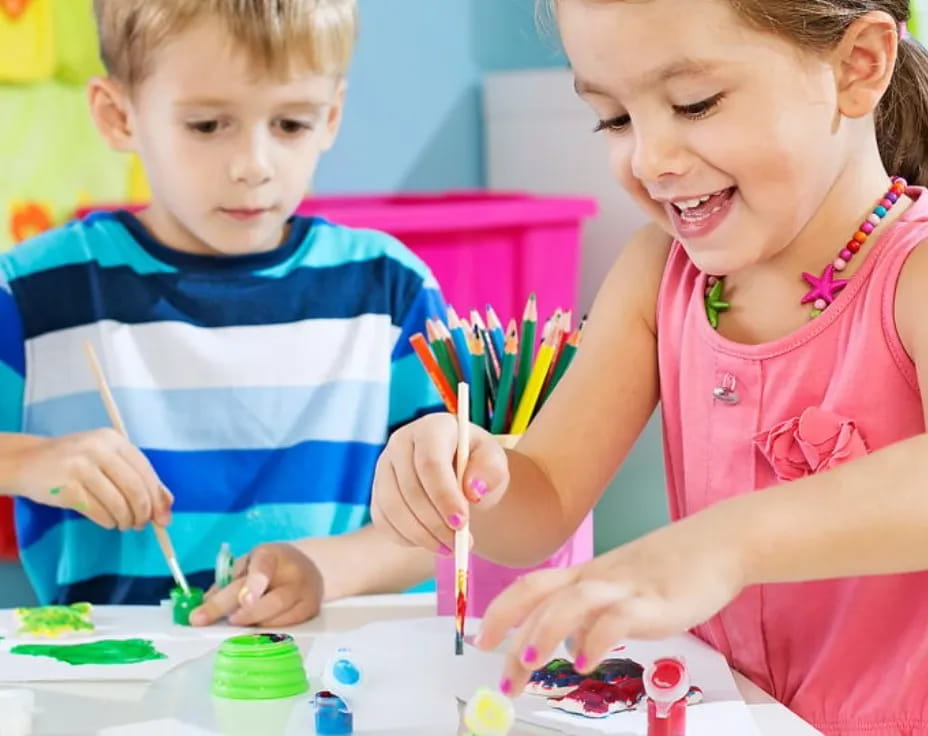 a couple of children painting
