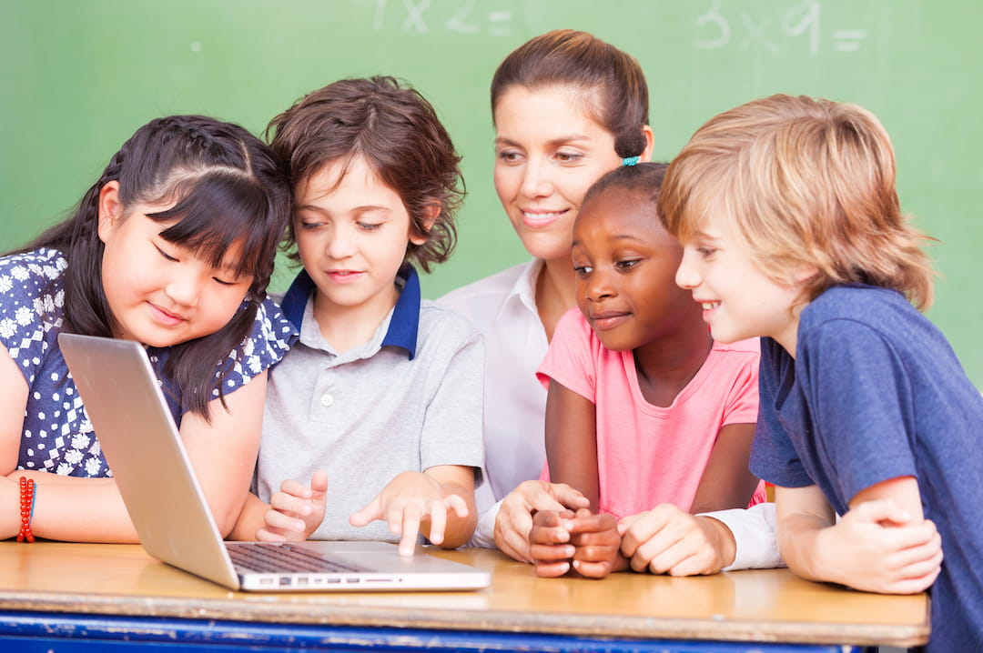 a group of children looking at a laptop