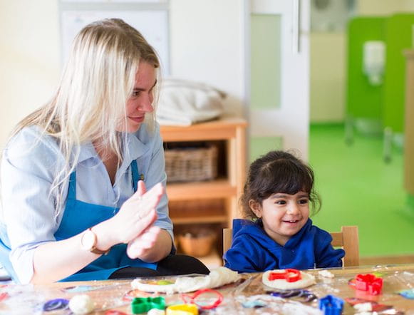 a person and a boy playing with toys on a table