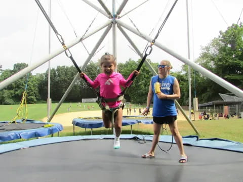 a person and a girl on a swing set