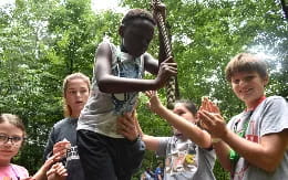 a group of children holding up a stick