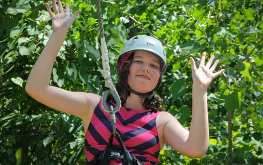 a person wearing a helmet and climbing a tree