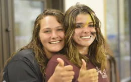 two women smiling and pointing