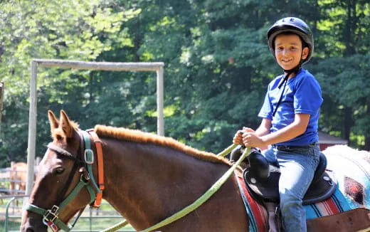 a young boy riding a horse