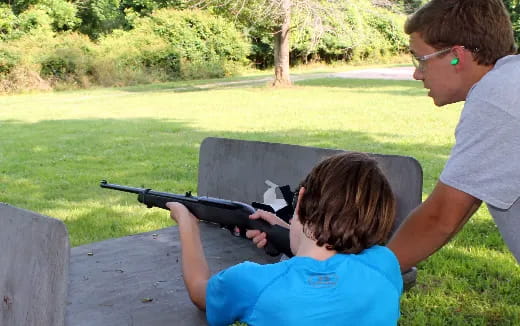 a man and a child shooting a gun