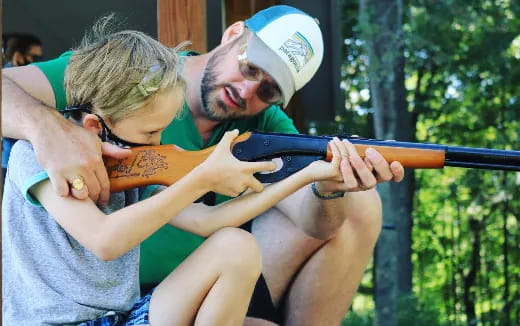 a man and woman holding a gun