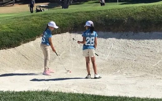 a couple of people playing golf