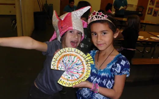 a couple of kids holding a large disc
