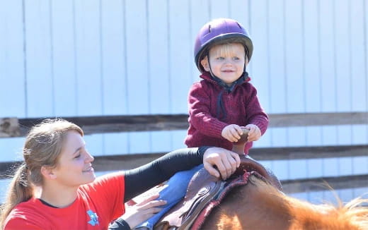 a person riding a horse with a child on the back