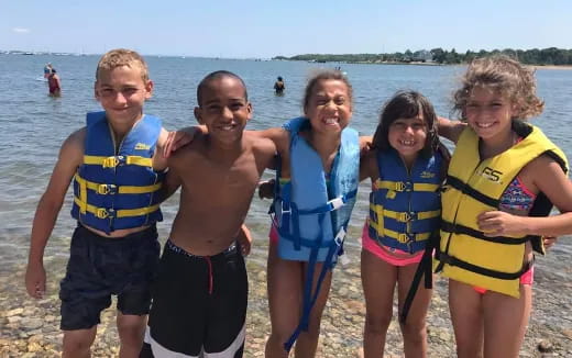 a group of people posing for a photo on a beach