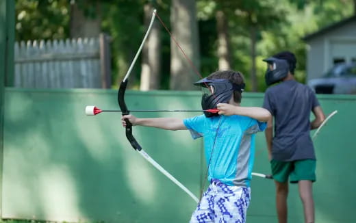 a group of people playing with bows and arrows
