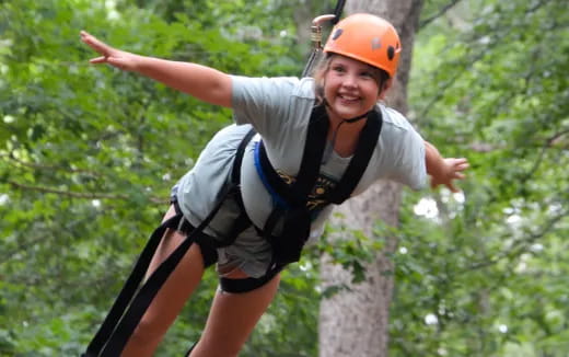 a person wearing a helmet and climbing a tree