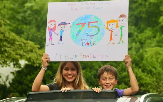a person and a boy holding a sign