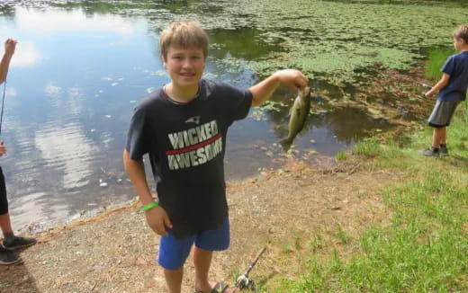 a boy holding a fish