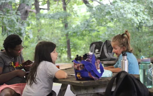 a group of people sitting at a table outside