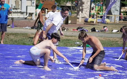 a group of people playing with a rope on a beach