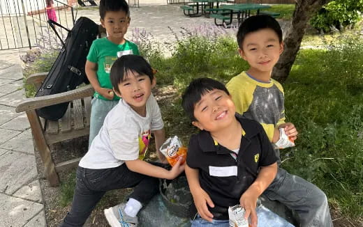 a group of boys sitting on a bench outside