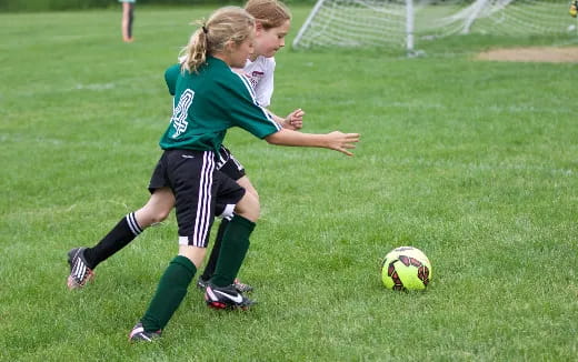 girls playing football on a field