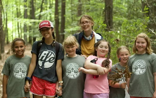 a group of people posing for a photo in the woods
