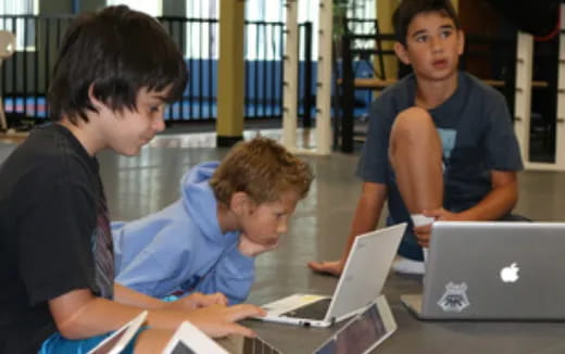 a group of people working on laptops