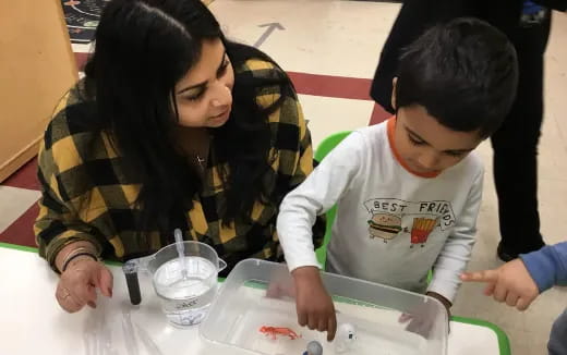 a person and a boy looking at a paper