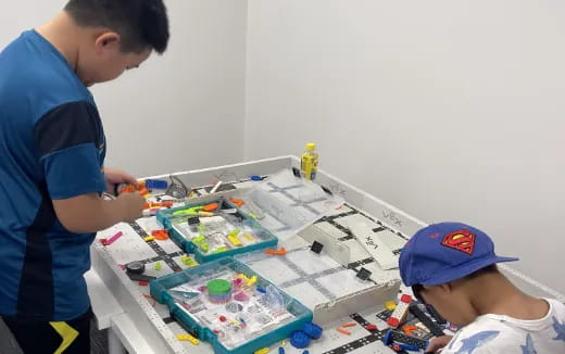 a person and a baby playing with toys on a table