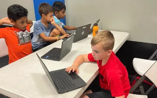 a group of kids using laptops