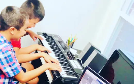 a couple of boys playing piano