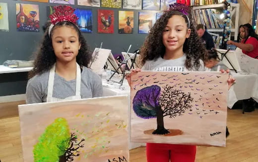 a couple of girls holding a drawing