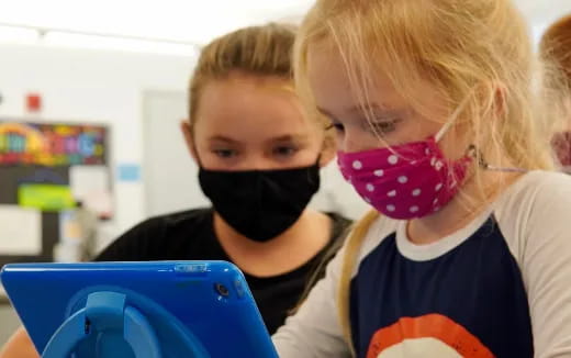 a couple of kids looking at a computer screen