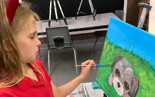 a woman painting a bird