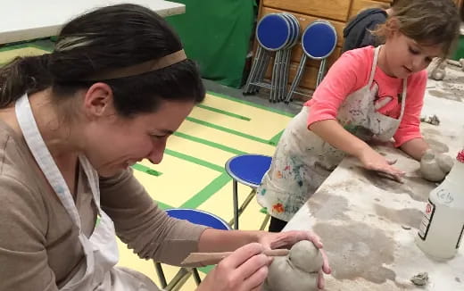 a person and a girl playing with sand