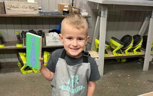 a boy smiling with his hand on his hip