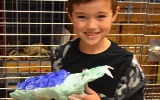 a boy holding a parrot