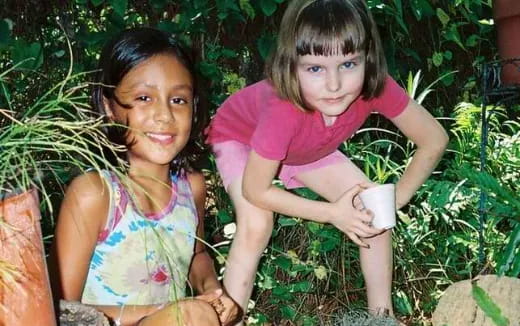 a couple of girls sitting in the grass