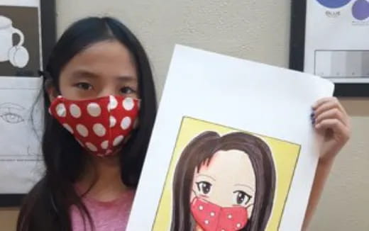 a girl holding a drawing