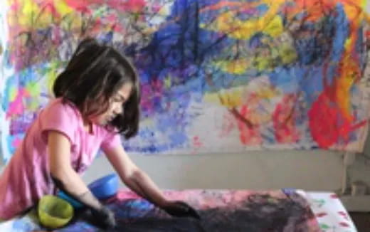 a girl painting a wall