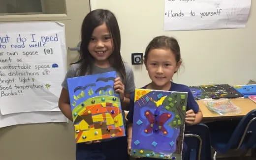 a couple of girls holding books