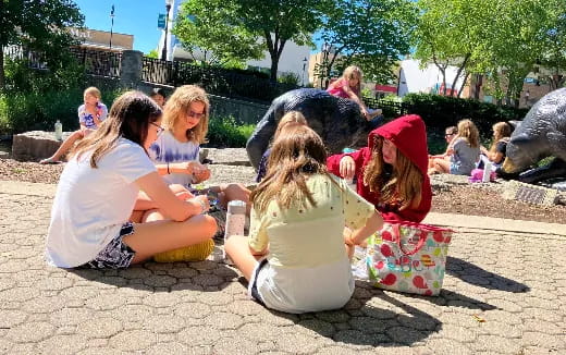 a group of people sitting on the ground outside