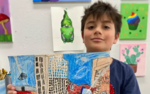 a boy holding a stack of magazines